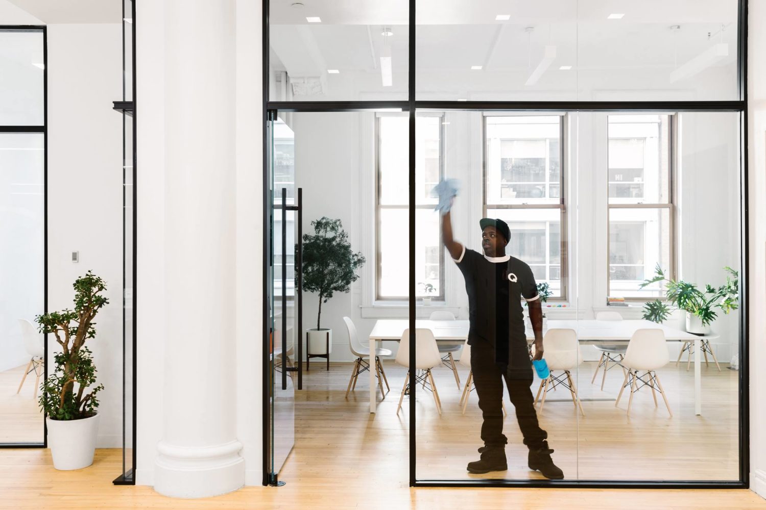 a man cleaning the glass walls in an office building