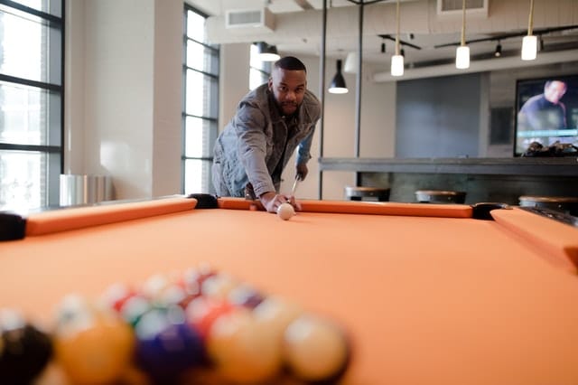 a man playing billiards at a coworking space in new york