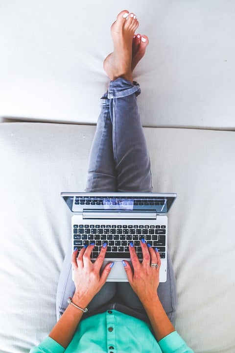 a lady using a laptop for work on a coworking space's sofa