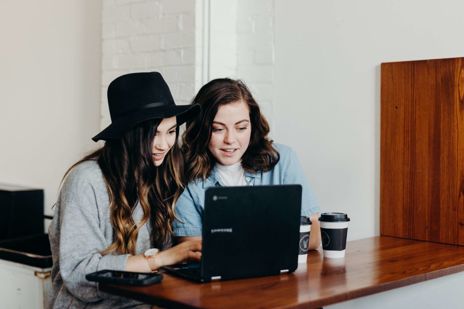 Two women watching a laptop