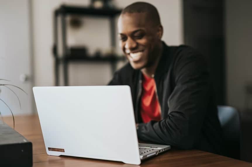 man smiling while using laptop