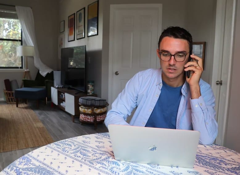 man on his phone and laptop working from home