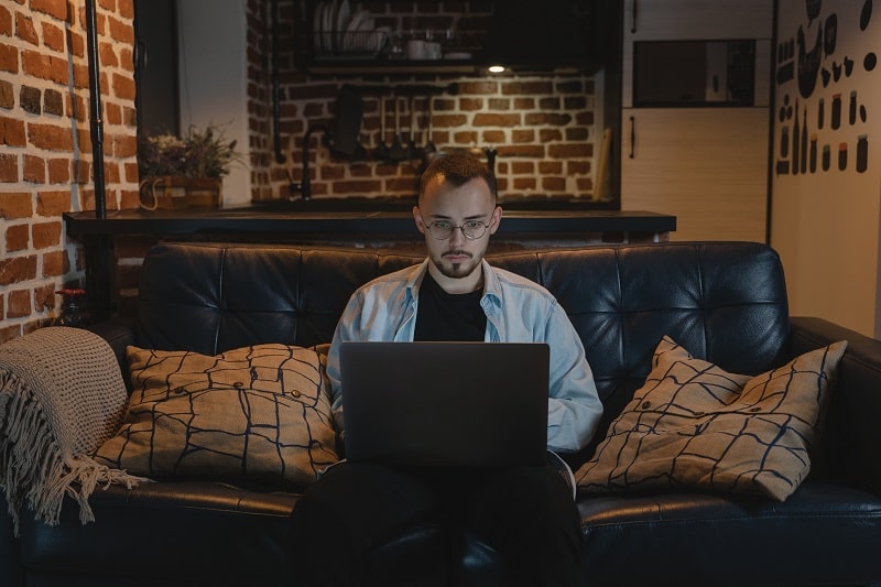 a person sitting on a couch with laptop