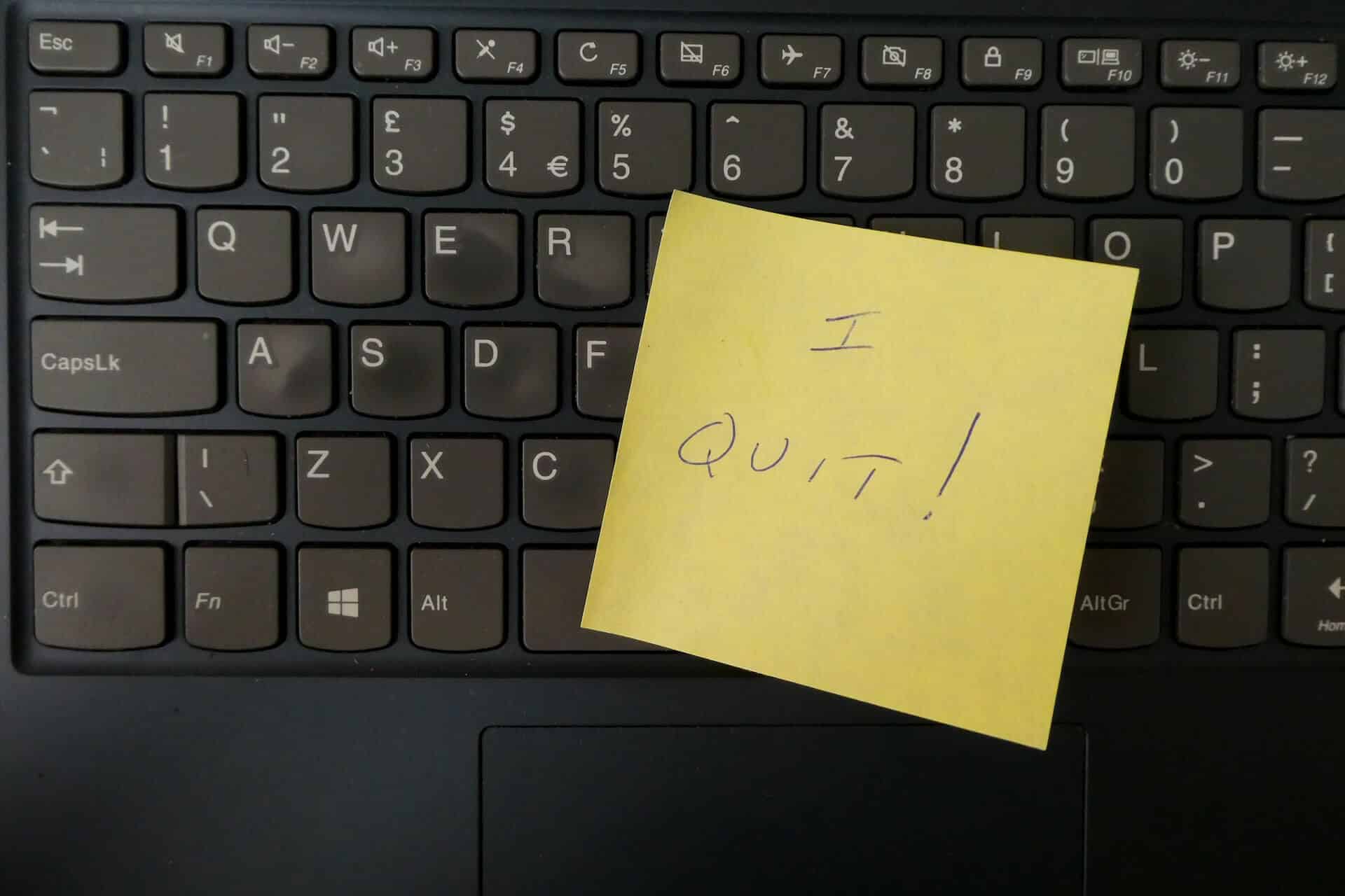 photograph of a sticky note with the words I QUIT attached to a keyboard to signify how not to write a resignation letter