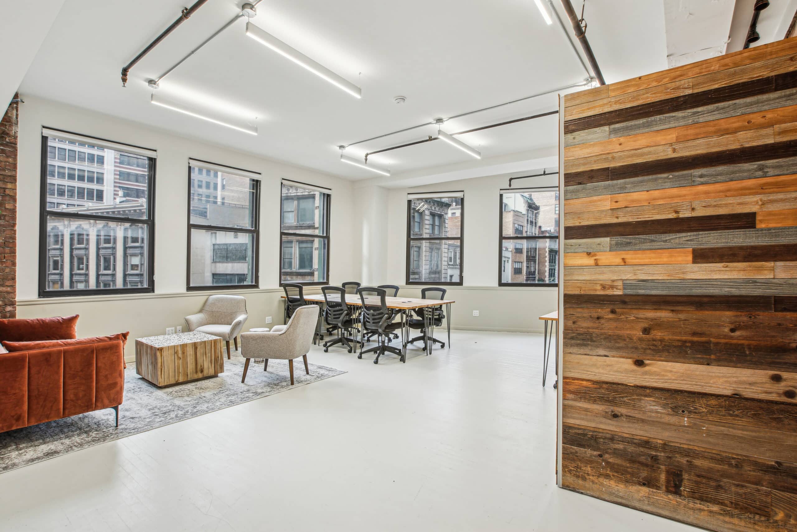 A well-appointed office showcasing wood paneling and a cozy couch, perfect for a productive work atmosphere.